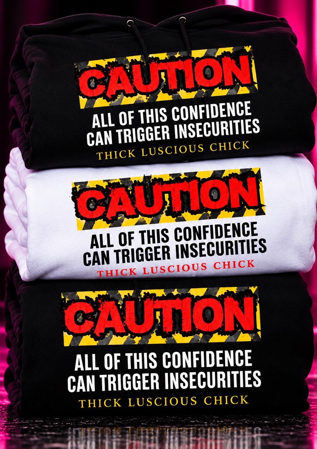 Folded black and white Caution collection hoodies and tee